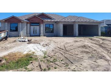 Under construction house with front door and two-car garage on a sunny day at 254 White Marsh Ln, Rotonda West, FL 33947