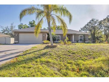 Charming single-story home with a well-maintained lawn and a palm tree in the front yard at 6345 Bodmin Ln, North Port, FL 34291