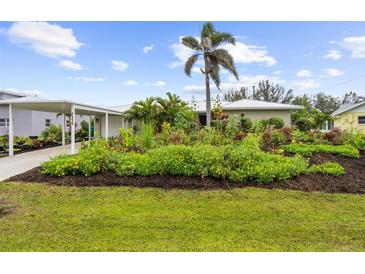 Charming home featuring lush landscaping and a beautiful palm tree at 7339 Thomas St, Englewood, FL 34224