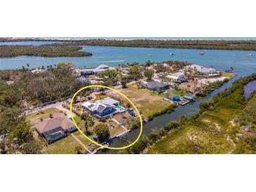 Beautiful waterfront property with a pool and private dock on a sunny day at 50 Spyglass Aly, Placida, FL 33946