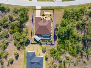 Beautiful aerial view of the home showing the private pool, large yard, and desirable landscaping at 8251 Arlewood Cir, Port Charlotte, FL 33981