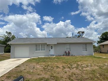 Charming single-story home featuring a well-maintained lawn, attached garage, and inviting front entrance at 11090 Mcfadden Ave, Englewood, FL 34224