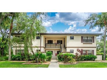 Inviting two-story condo with charming exterior, lush landscaping, and convenient stair access to the upper units at 19505 Quesada Ave # B202, Port Charlotte, FL 33948