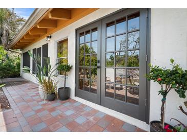Charming patio with brick pavers, lush plantings, and double doors for seamless indoor-outdoor living at 2760 Lemon Ave, Englewood, FL 34223