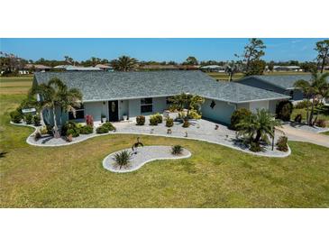 Well-maintained home with a landscaped front yard, gray roof, manicured lawn, and fresh exterior paint at 62 Oakland Hills Pl, Rotonda West, FL 33947