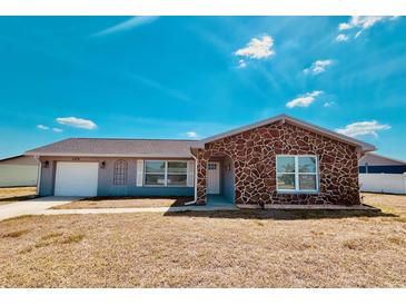 Charming single-story home with stone accents, attached garage, and well-maintained lawn at 6375 Coniston St, Port Charlotte, FL 33981