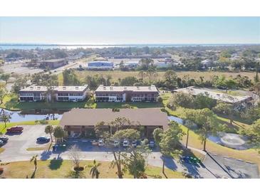 Aerial view of property surrounded by lush landscaping and water features, offering a serene setting at 11 Quails Run Blvd # 9, Englewood, FL 34223