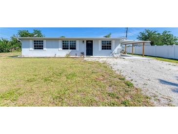 Charming single-story home with light blue exterior, well-maintained lawn, and convenient carport at 1160 Sharlo Cir, Englewood, FL 34224