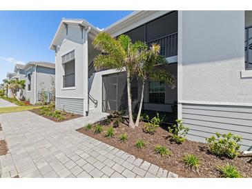 Charming exterior featuring a screened patio, two-tone siding, and professionally landscaped yard at 17505 Opal Sand Dr # 101, Venice, FL 34293