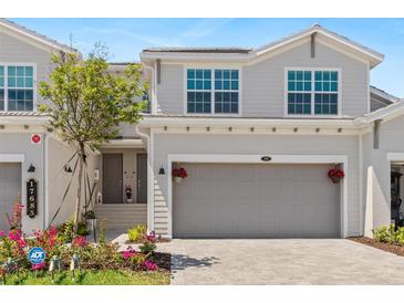 Charming townhome featuring an attached garage, well-maintained landscaping, and inviting front entrance at 17685 Boracay Ct # 202, Venice, FL 34293