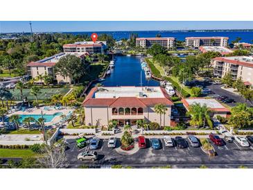 Scenic aerial view of community with a pool, tennis court, canal access, and ample parking at 25188 Marion Ave # D308, Punta Gorda, FL 33950