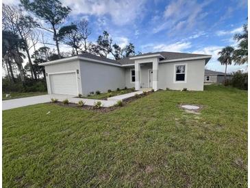 A charming single-story home featuring a well-manicured lawn and attached one car garage at 302 Albatross Rd, Rotonda West, FL 33947