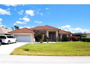 Charming single-story home features a well-maintained lawn, two-car garage, and a beautiful tile roof at 76 Sportsman Rd, Rotonda West, FL 33947