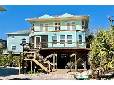 Stunning elevated coastal home featuring a spacious porch and outdoor living space at 8152 Little Gasparilla Is, Placida, FL 33946