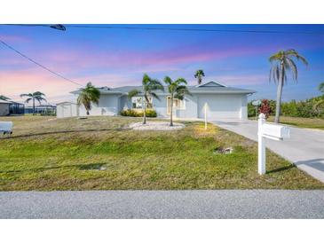 Charming single-story home with a well-manicured lawn and beautiful palm trees enhancing its curb appeal at 15184 Aldama Cir, Port Charlotte, FL 33981