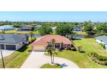 Waterfront home with well-maintained lawn and large circular driveway at 1080 Boundary Blvd, Rotonda West, FL 33947