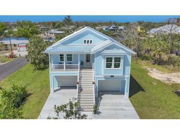 Charming coastal home with a metal roof, double garage, and inviting staircase at 1141 Andrews St, Englewood, FL 34224