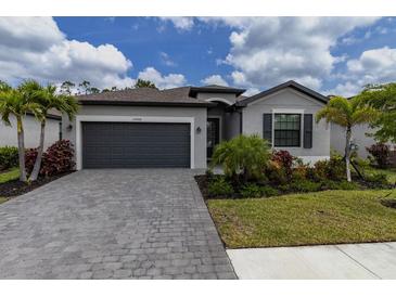 Attractive single-Gathering home with a stone-paved driveway and neatly manicured lawn at 15968 Honeysuckle St, Port Charlotte, FL 33953