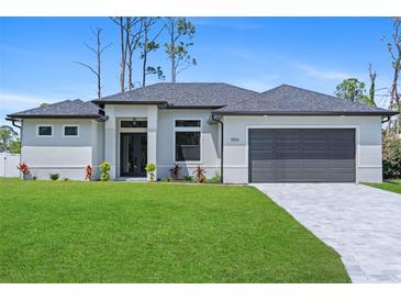 Beautiful, single-story home with a manicured lawn, gray roof, and neutral exterior paint at 1826 Narrington Ave, North Port, FL 34288