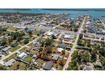 Aerial view of a home with a sprawling, tree-filled yard, surrounded by streets and waterways at 2033 Georgia Ave, Englewood, FL 34224