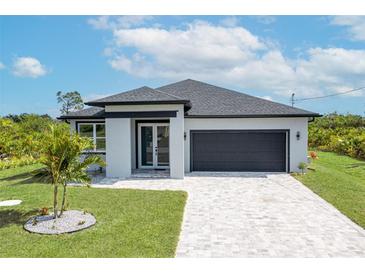 Charming single-story home featuring a gray roof, a gray garage door, and a well-manicured lawn at 234 Cougar Way, Rotonda West, FL 33947