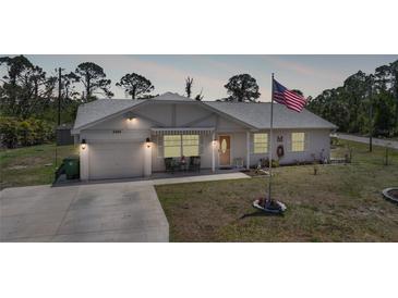 Charming single-story home featuring a well-maintained yard and an American flag waving proudly at 5460 Norlander Dr, Port Charlotte, FL 33981