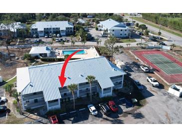 Aerial view of condo complex with tennis courts, pool, and parking at 6800 Placida Rd # 227, Englewood, FL 34224