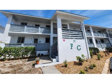 Two-story condo with balconies and gray railings, green shrubbery and landscaping in front at 6800 Placida Rd # F294, Englewood, FL 34224