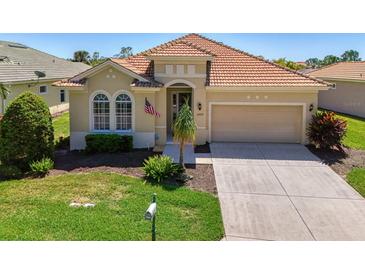 Charming single-story home featuring a red tile roof, manicured lawn, and a two-car garage at 13217 Scrub Jay Ct, Port Charlotte, FL 33953