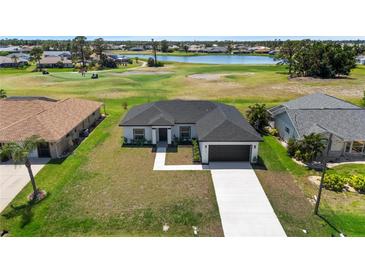 Beautiful one-story home overlooking a golf course with a lush green lawn and a paved driveway at 166 Bunker Rd, Rotonda West, FL 33947