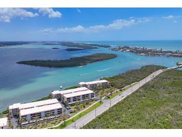 Stunning aerial view of waterfront condos, with lush landscaping and beautiful ocean views at 1701 Beach Rd # 208, Englewood, FL 34223