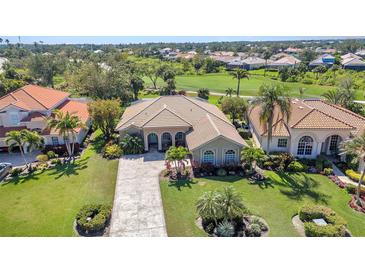 Aerial view of a home with manicured lawn and a paver driveway, surrounded by lush landscaping at 3511 Bay Ridge Way, Port Charlotte, FL 33953