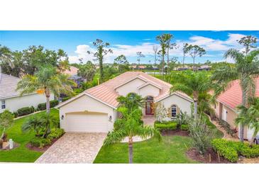 Charming single-story home with a tile roof, paver driveway, and beautifully landscaped front yard at 5433 White Ibis Dr, North Port, FL 34287