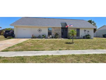 Charming single-story home with a well-maintained lawn and an attached two-car garage at 6540 Coliseum Blvd, Port Charlotte, FL 33981