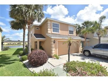Charming two-story home with a two-car garage, well-maintained lawn, and mature palm trees at 11750 Tempest Harbor Loop, Venice, FL 34292