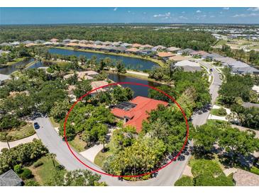 An aerial view of a single-Gathering home encircled by trees, near a lake and waterway at 26 Saint Croix Way, Englewood, FL 34223