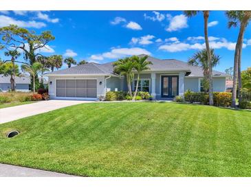 Charming single-story home boasts a beautifully manicured lawn and tropical landscaping, creating a welcoming curb appeal at 27 Sportsman Cir, Rotonda West, FL 33947