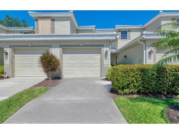 Inviting two-story townhouse featuring a two-car garage, well-maintained landscaping, and a neutral color scheme at 3433 Grand Vista Ct # 102, Port Charlotte, FL 33953
