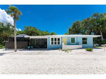 Charming blue single-story home with a screened-in porch and well-kept landscaping at 4065 N Beach Rd # A, Englewood, FL 34223