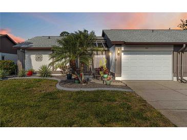 Charming single-story home features a well-manicured lawn, lovely landscaping, and an attached two-car garage at 667 Foxwood Blvd, Englewood, FL 34223