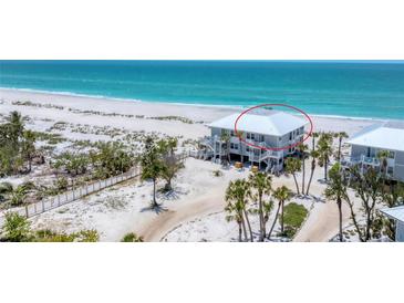 Lovely coastal home with white exterior, multiple balconies, and beach access, showcasing a serene waterfront lifestyle at 7554 Palm Island S Dr # 1822, Placida, FL 33946