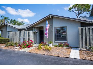Charming home featuring a cozy entrance with an American flag and colorful landscaping at 148 Jose Gaspar Dr # 148, Englewood, FL 34223