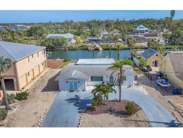 Charming waterfront home featuring a well-maintained lawn, mature palms and a private drive at 17 Southwind Dr, Englewood, FL 34223