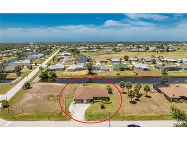 Waterfront home with mature landscaping, circular drive, and proximity to a golf course at 39 Bunker Pl, Rotonda West, FL 33947