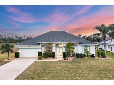 Inviting single-story home featuring lush landscaping, a two-car garage, and a well-manicured lawn at 642 Boundary Blvd, Rotonda West, FL 33947