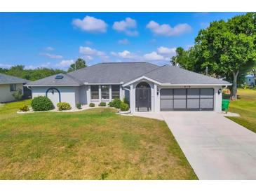 Charming single-story home with a well-manicured lawn and attached garage at 1035 Riggs St, Port Charlotte, FL 33952