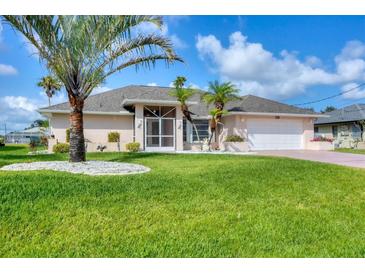 Charming single-story home with lush lawn, palm trees, and a well-manicured landscape at 119 Fairway Rd, Rotonda West, FL 33947