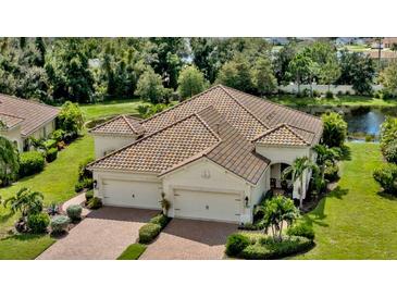 Beautiful exterior showcasing a tile roof, three-car garage, and lush landscaping at 1339 Backspin Dr, Englewood, FL 34223