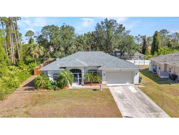Well-maintained single-story home featuring manicured landscaping and an attached two-car garage at 1962 Remus Ave, North Port, FL 34286
