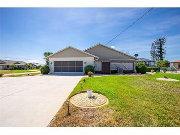 Well-maintained, single-story home with an attached garage, lush green lawn, and inviting curb appeal under a clear blue sky at 204 Bunker Rd, Rotonda West, FL 33947